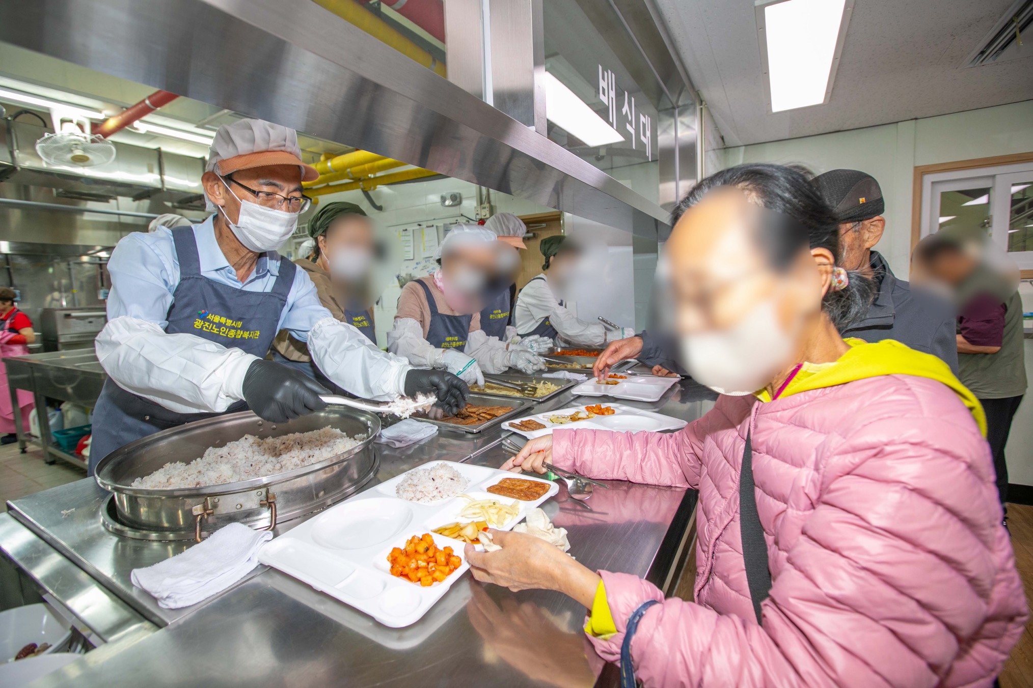 [김현준 한국사회보장정보원장(왼쪽 첫 번째)과 임직원들이 2일(수) 광진노인종합복지관에서 어르신들에게 따뜻한 점심 한끼를 대접하는 배식봉사에 참여하고 있다./한국사회보장정보원]