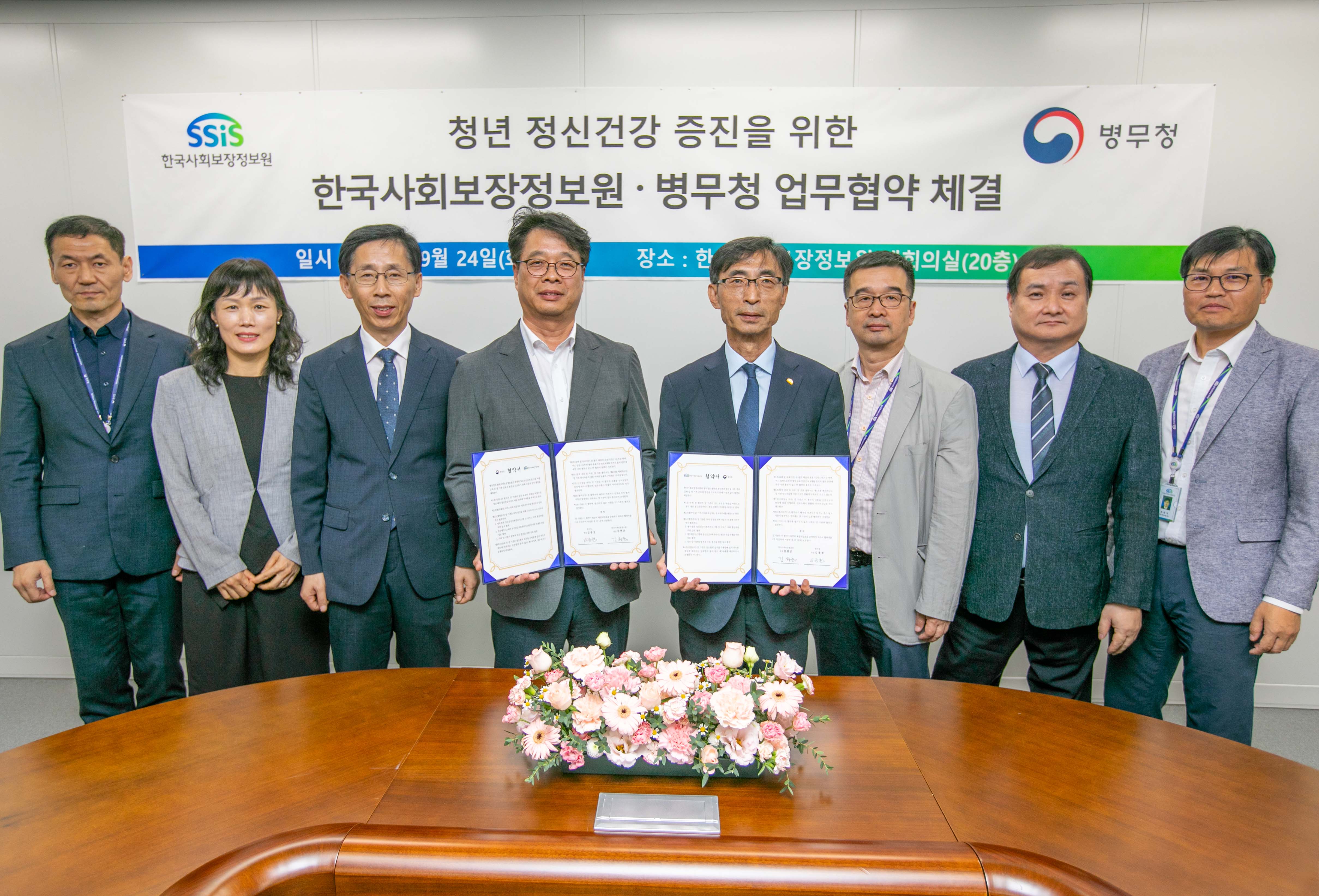 김현준 한국사회보장정보원장(우측)과 최규석 병무청 차장(좌측)이 청년 정신건강 증진을 위한 업무협약서에 서명한 뒤 양 기관 임직원들과 함께 기념촬영을 하고 있다.